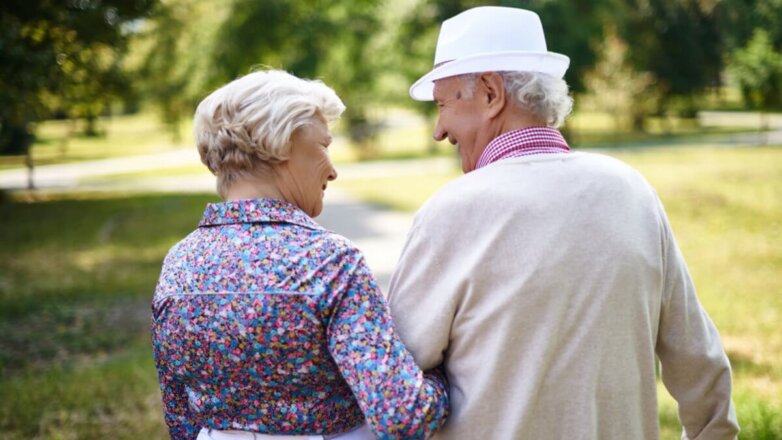 Счастливая пожилая пара на прогулке в парке пенсионеры