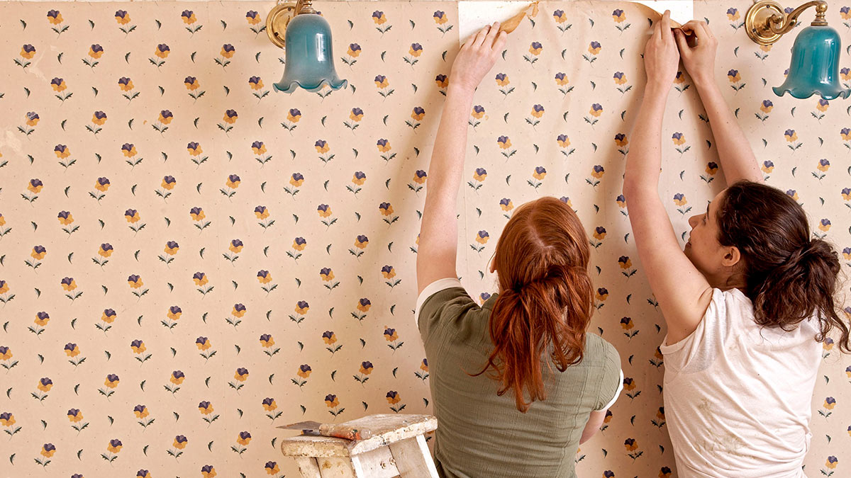 Женщины подклеивают обои