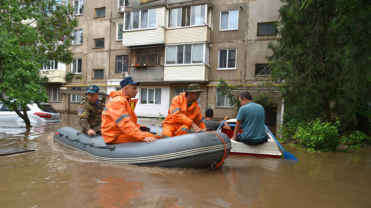 Спасатели перемещаются на лодке по улице в центре Керчи.