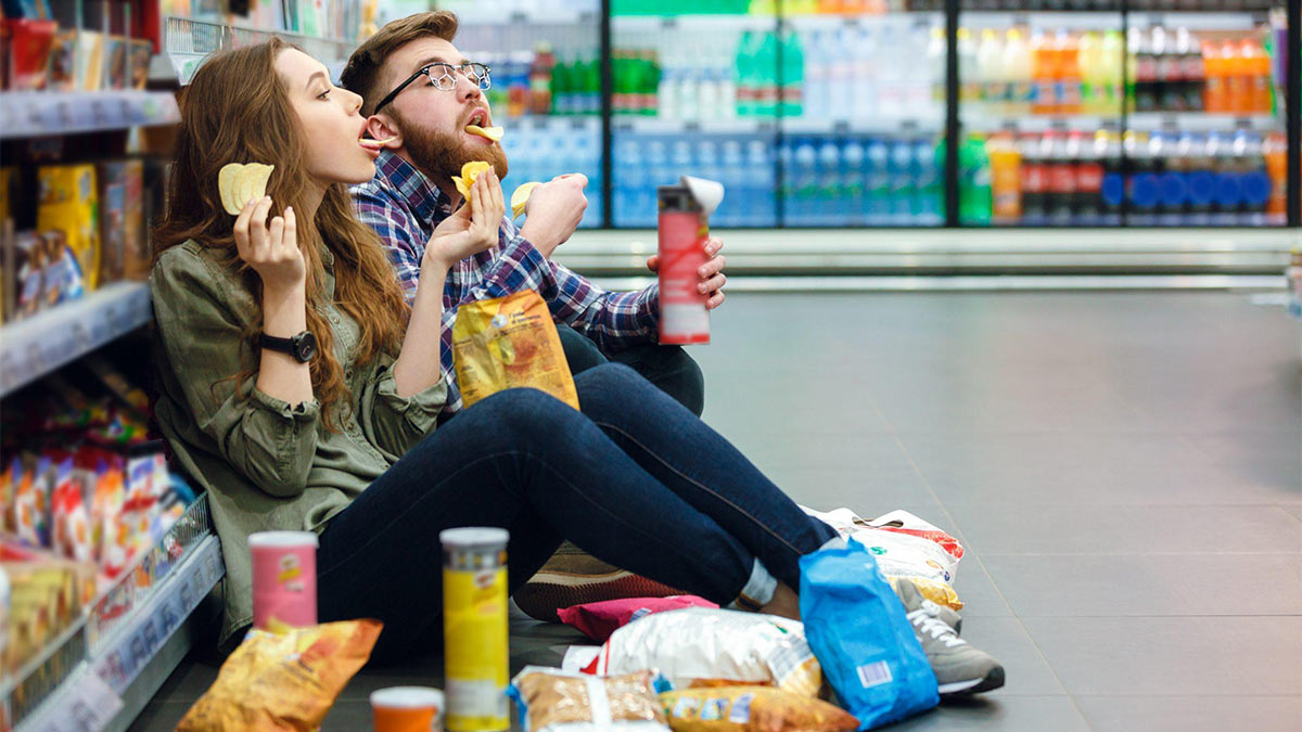Люди едят чипсы в магазине
