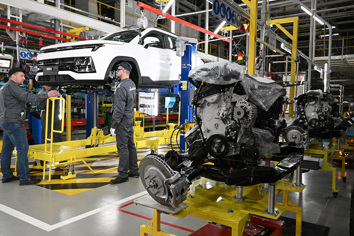 Рабочие за сборкой автомобиля на производственной линии Московского автомобильного завода "Москвич".