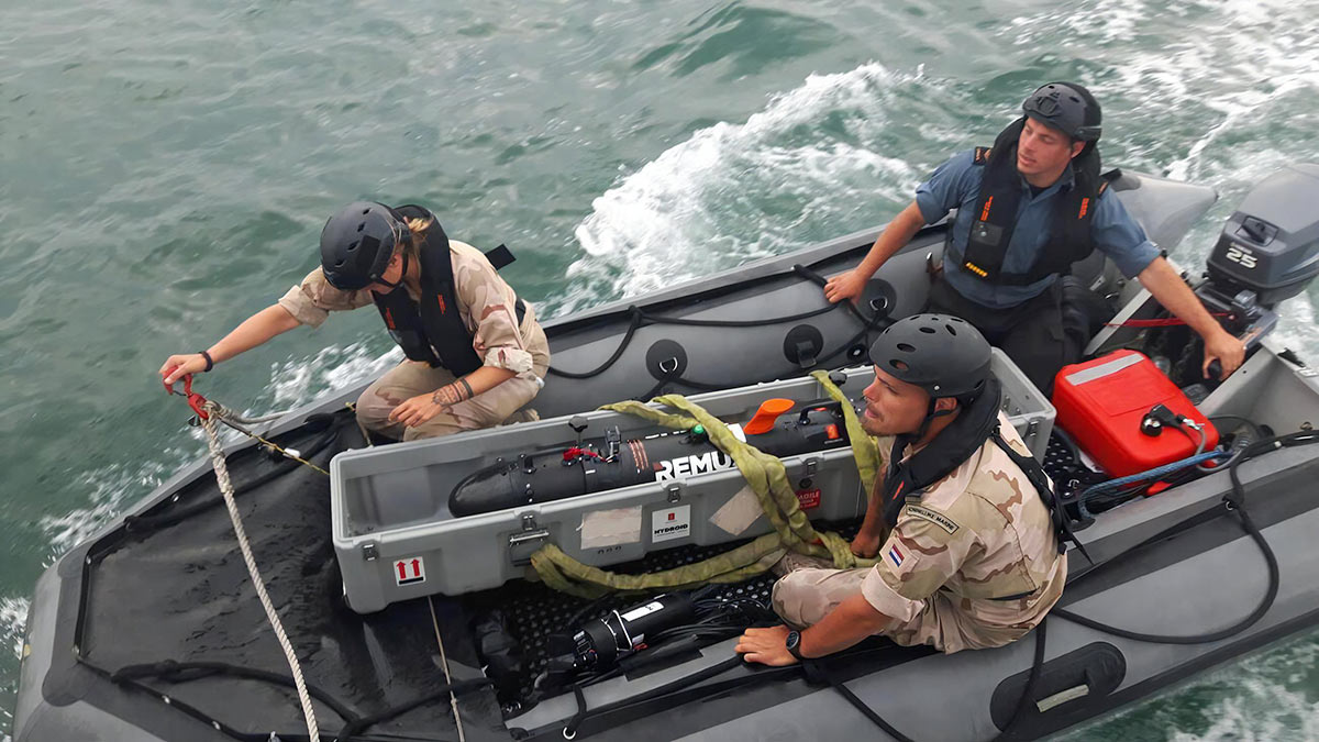 Операторы беспилотных подводных аппаратов перемещаютREMUS 100 для исследовательской миссии по поиску мин