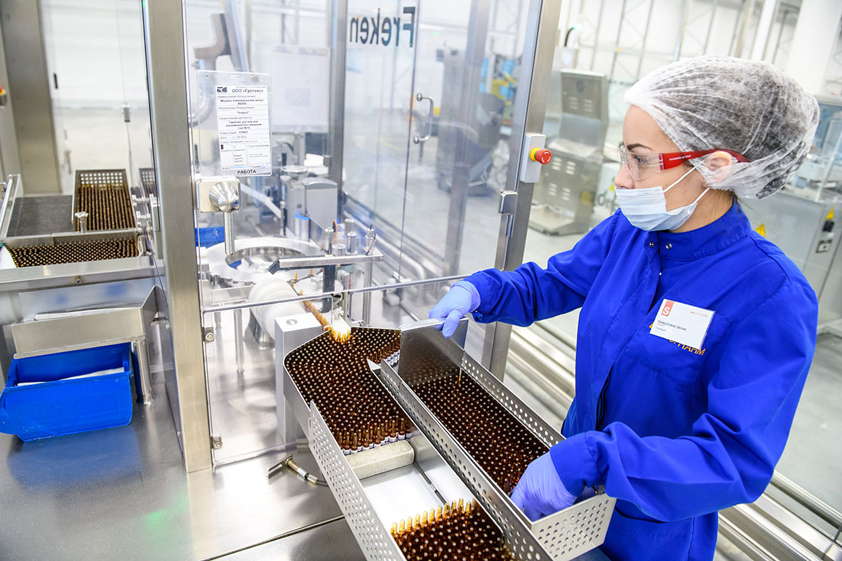 Сотрудница во время работы на заводе по производству твердых лекарственных форм, капсул и таблеток
