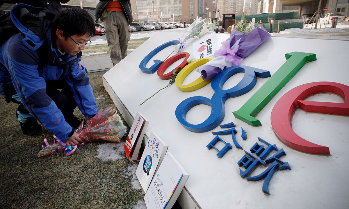 Мужчина возлагает цветы возле штаб-квартиры Google в Пекине