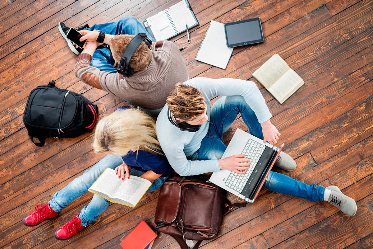 Студенты со смартфонами, ноутбуками, тетрадями, книгами