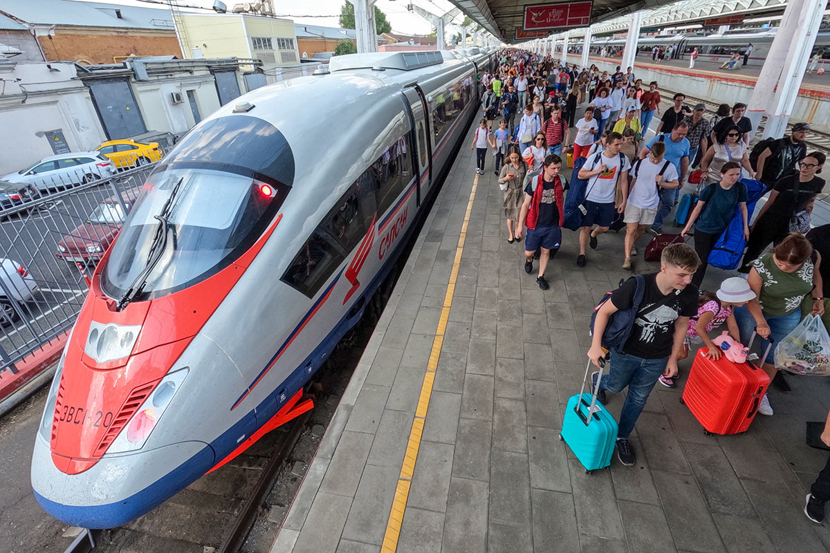 Пассажиры на платформе около высокоскоростного поезда "Сапсан"