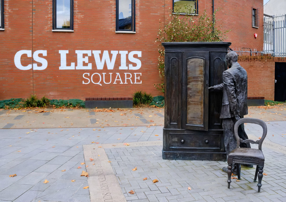 Человек, вторгающийся в скульптуру гардероба на площади К.С. Льюиса в восточном Белфасте