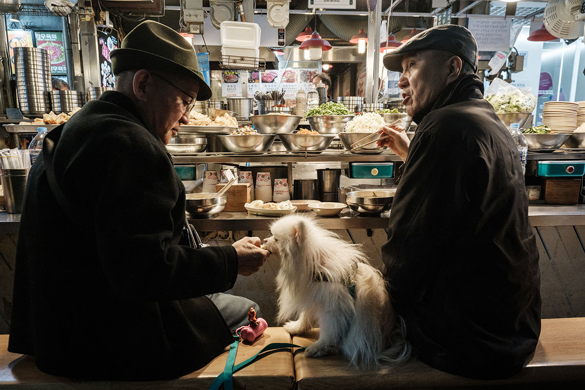 Мужчины с собакой на рынке в Южной Корее