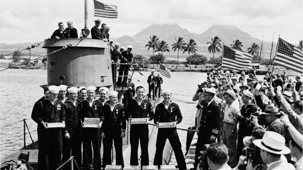 Перл-Харбор, Гавайи, 2 марта 1942 года. Экипаж подводной лодки USS Trout (SS‑202), вернувшейся из патруля к осаждённому Коррехидору, демонстрирует золотые слитки, вывезенные с Филиппин, во время церемонии на пирсе военно-морской базы. Матросы, награждённые Военно-морскими крестами за успешную боевую операцию и спасение драгоценного груза, позируют перед представителями прессы и командованием Тихоокеанского флота на фоне флагов США и гавайских пейзажей. Снимок выполнен как официальная фотография ВМС США и в марте 1942 года был распространён Бюро военно‑морской пропаганды среди крупных газет и журнальных агентств. Фотография использовалась в пресс‑релизах о возвращении USS Trout и эвакуации филиппинского золота, публиковалась в изданиях Honolulu Star‑Bulletin и нескольких материковых газет США, а позднее вошла в послевоенный иллюстрированный альбом U.S. Navy о действиях подводных сил на Тихом океане